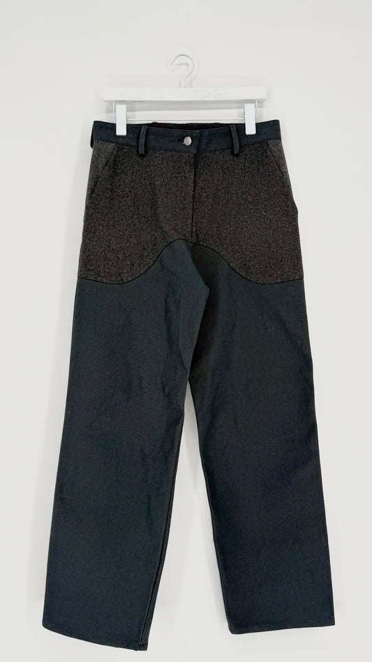 Black and gray pants on a white hanger against a white background