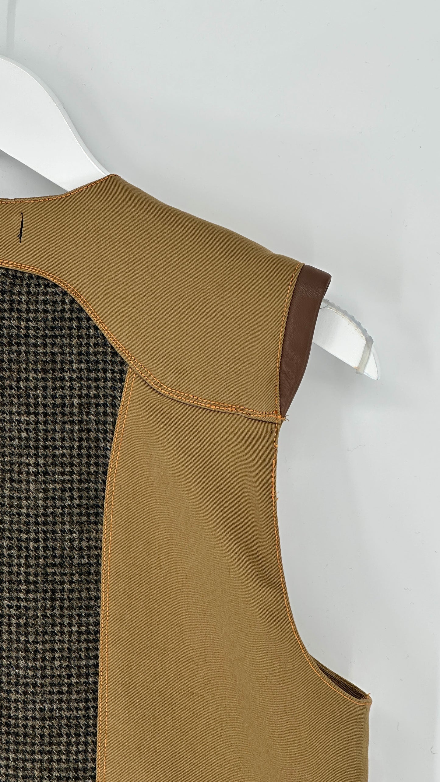 Brown vest with a textured back on a white hanger