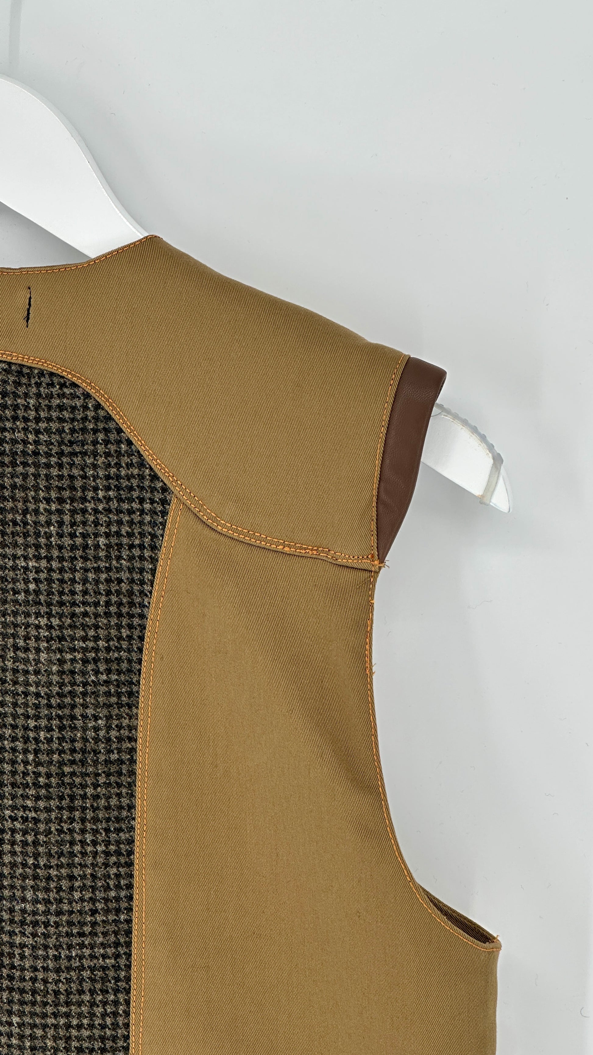 Brown vest with a textured back on a white hanger