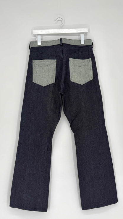 Dark denim jeans with gray patches on a white background