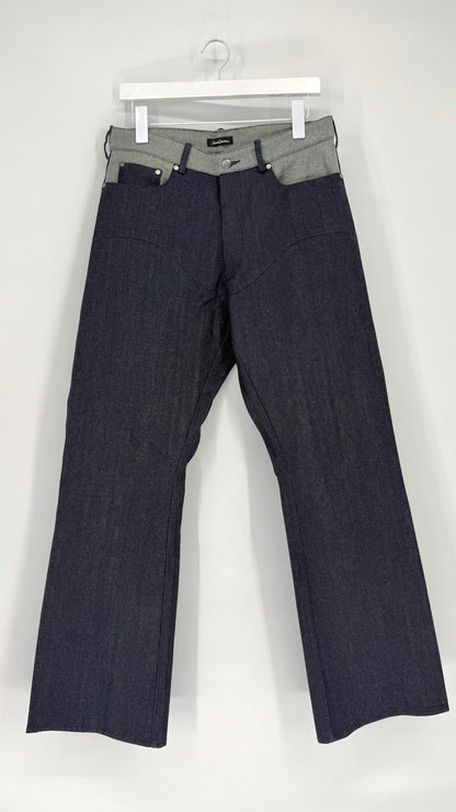 Dark blue jeans on a white hanger against a white background