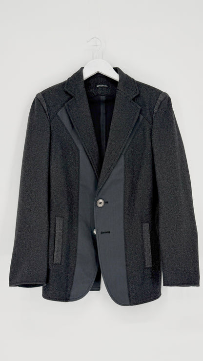 Gray blazer on a hanger against a white background