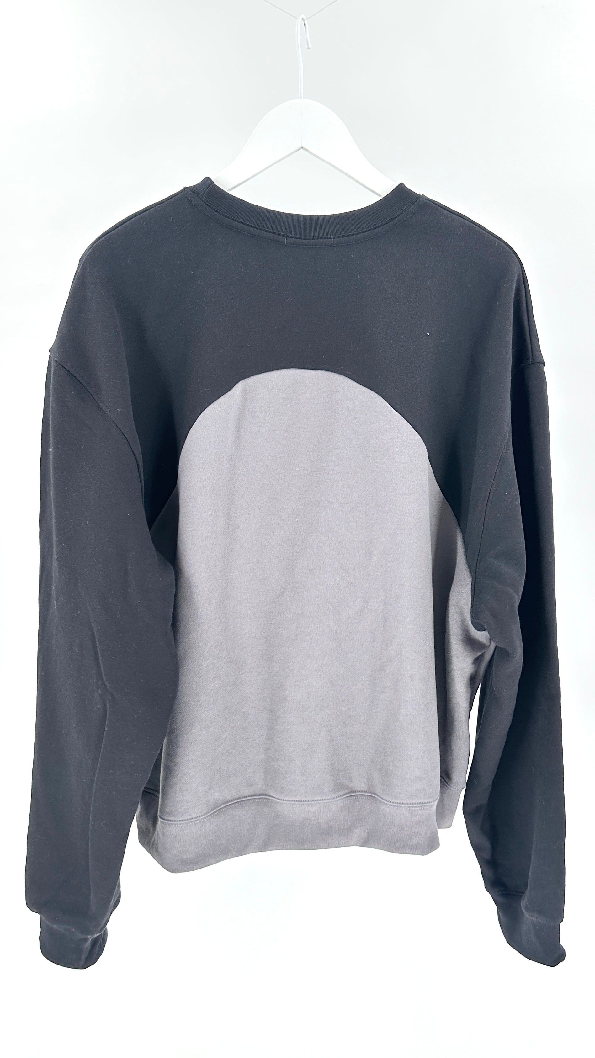 Gray and black sweatshirt on a white hanger against a white background