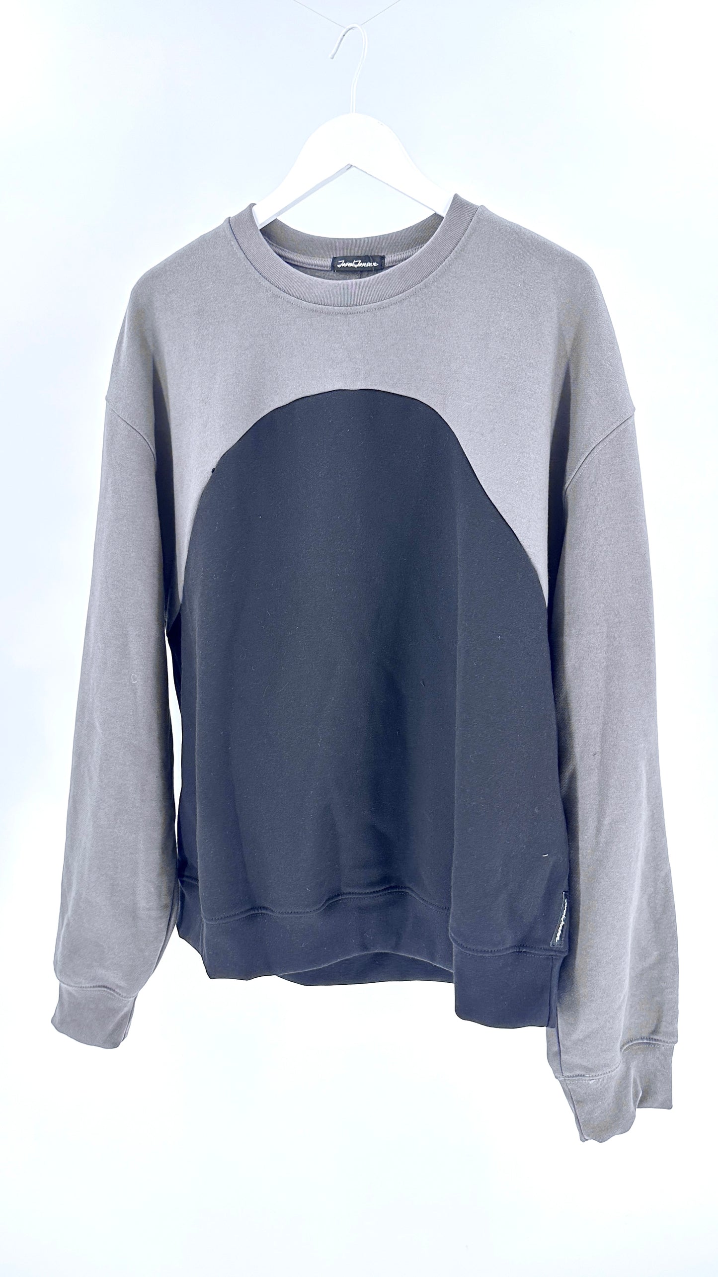 Gray and navy color-blocked sweatshirt on a hanger against a white background