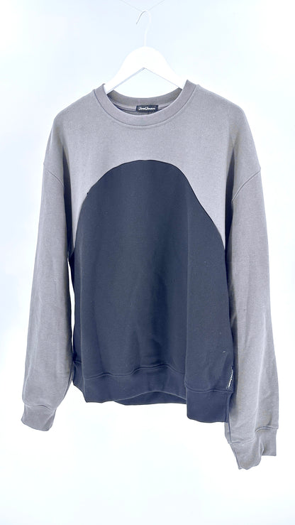 Gray and navy color-blocked sweatshirt on a hanger against a white background