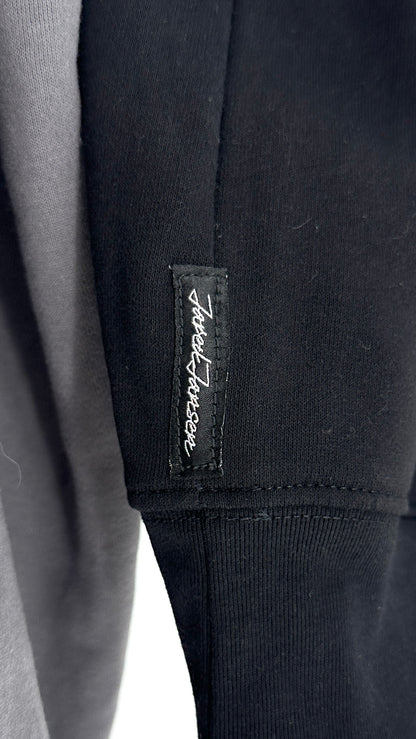 Close-up of a black garment with a brand label on a white background