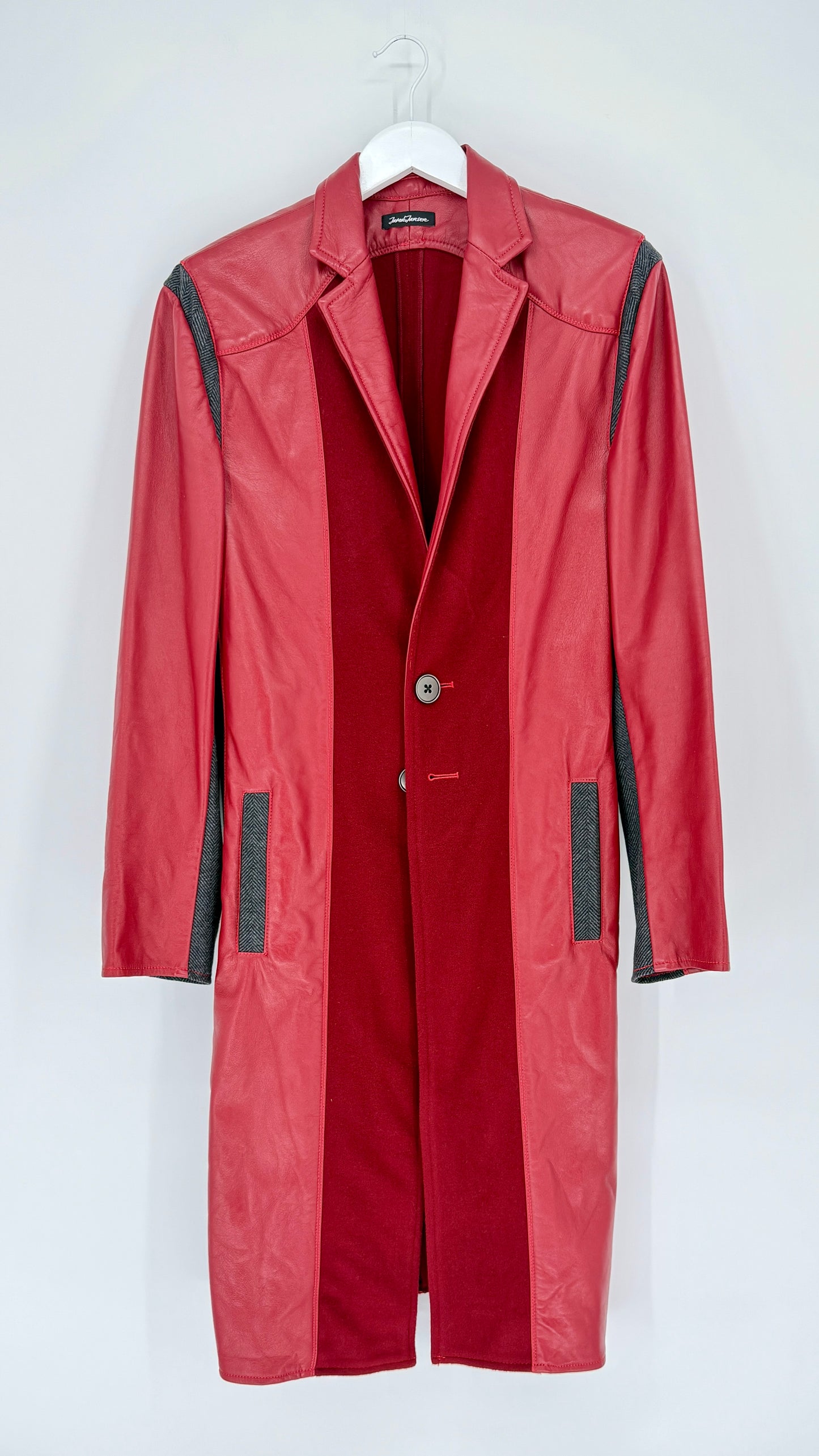 Red coat with black accents on a white hanger against a white background