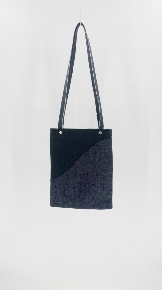 Black and gray handbag with a strap on a white background