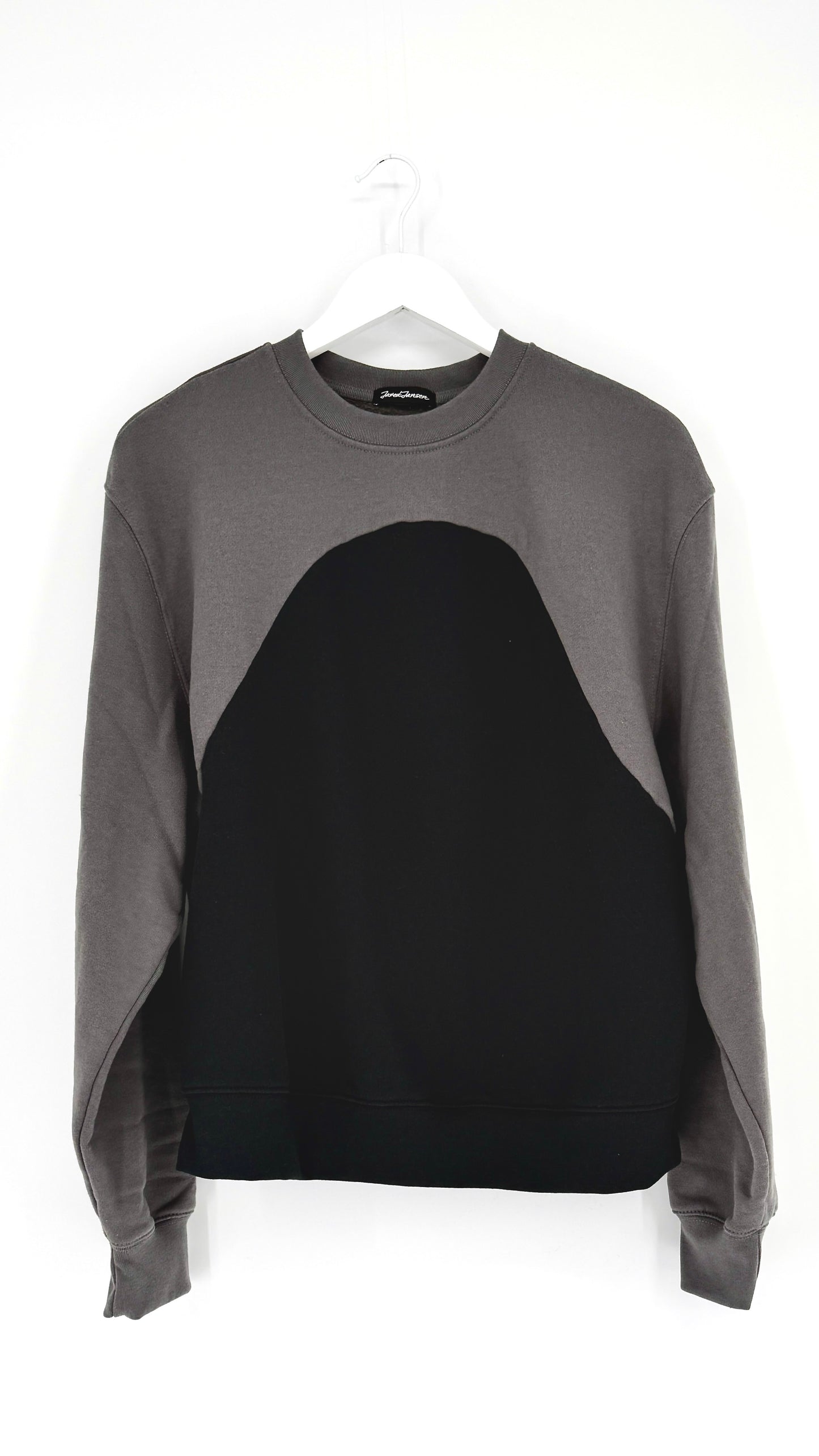 Gray and black sweater on a hanger against a white background