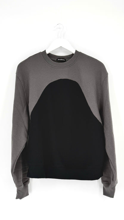 Gray and black sweater on a hanger against a white background