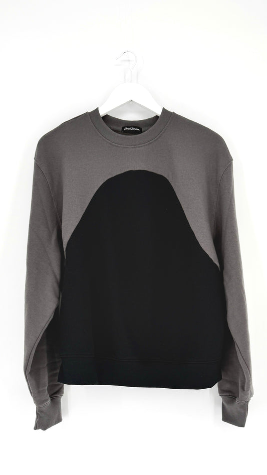 Gray and black sweater on a hanger against a white background