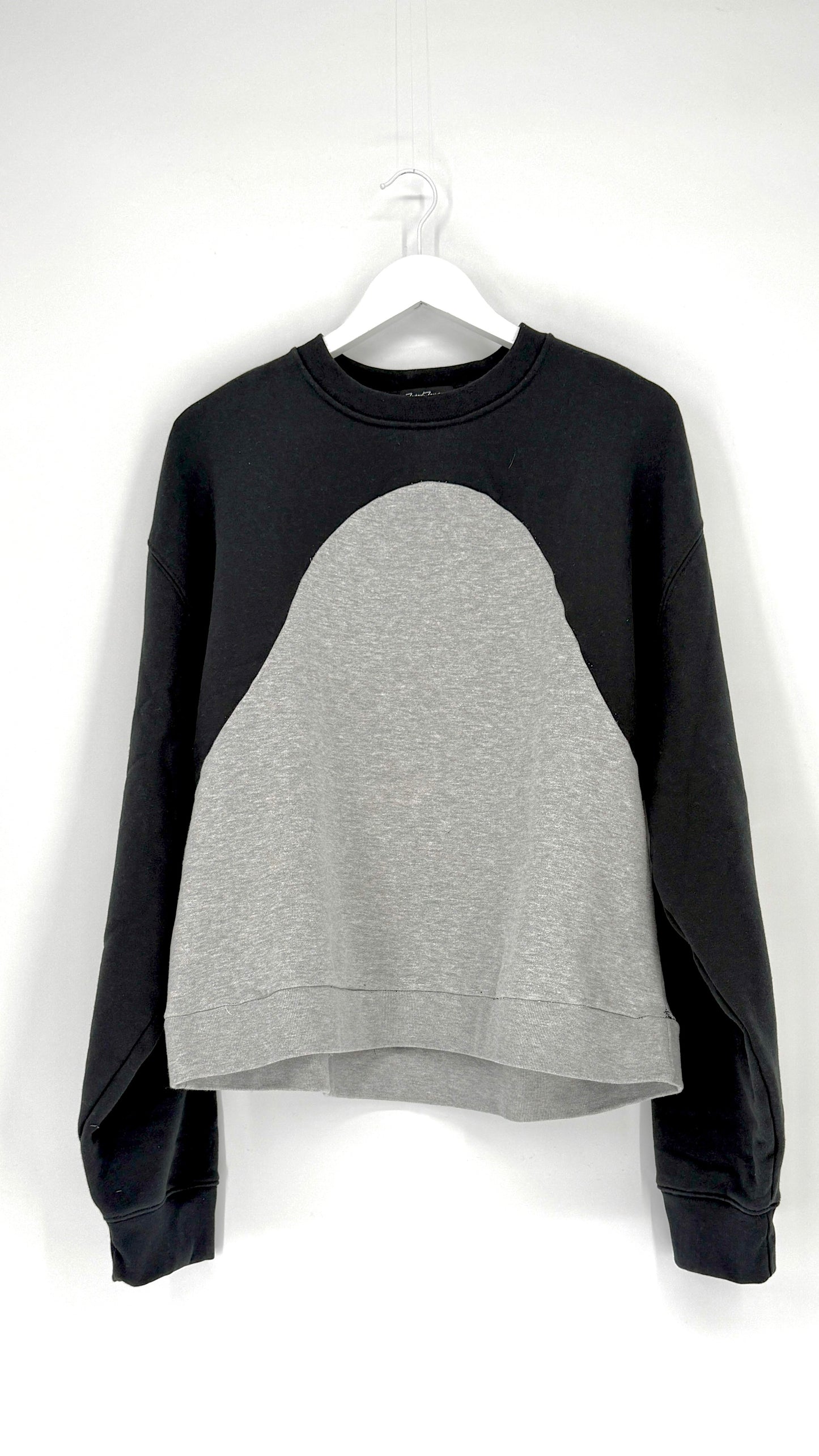 Black and gray sweatshirt on a hanger against a white background