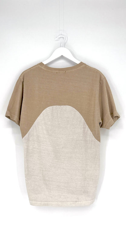Two-tone t-shirt with beige and white design on a hanger against a white background